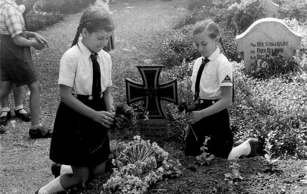 Above: Little BDM girls laying flowers on the graves of martyrs. 